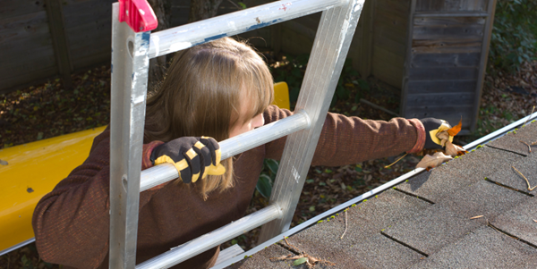 Lady on a ladder inspecting eavestroughing and roof